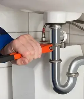 Plumbing work beneath a sink